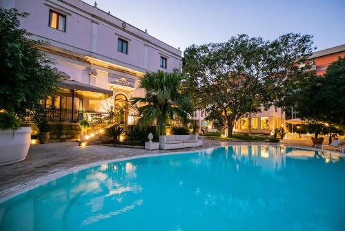 锡拉库扎帕可德佛坦尼酒店的大楼前的大型蓝色游泳池