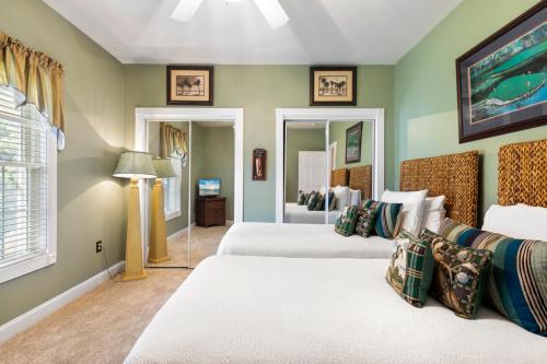 默特尔比奇Tranquil 3BR Condo in Magnolia Pointe near Myrtlewood Golf Resort的一间卧室配有两张床和镜子