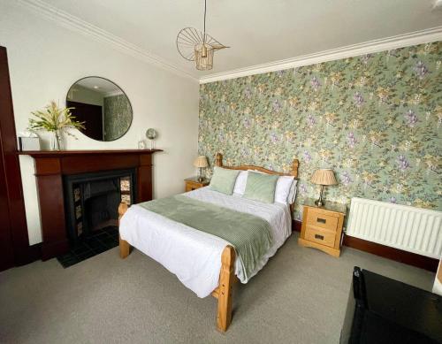 因弗内斯Crown House的一间卧室配有一张床、一个壁炉和一个镜子