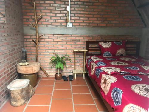 美寿Bầu Bí Mini Farmstay Mekong - Tiền Giang的一间设有床铺和砖墙的房间
