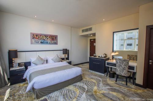 阿布扎比Grand Villaggio Hotel Abu Dhabi的配有一张床和一张书桌的酒店客房