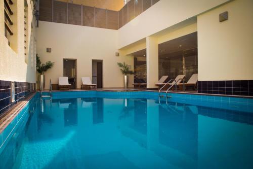 阿布扎比Grand Villaggio Hotel Abu Dhabi的大楼内一个蓝色的大型游泳池