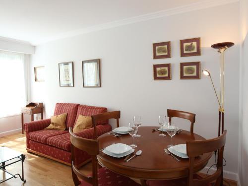 圣塞瓦斯蒂安Apartamento Ondarreta的客厅配有桌子和红色沙发