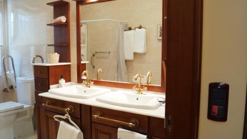比拉尔瓦Hotel Batán的一间带两个盥洗盆和大镜子的浴室