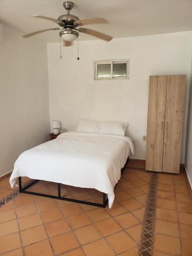 拉塞瓦Paradise Found的一间卧室配有一张床和吊扇