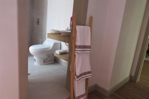 AtuntaquiTEYFA Hospedaje - Departamento的浴室配有卫生间、水槽和毛巾。