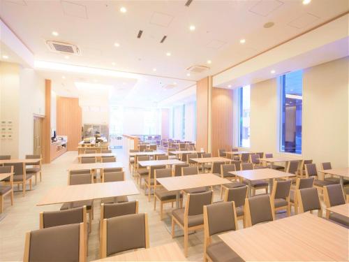 东京Tmark City Hotel Tokyo Omori - Vacation STAY 26381v的一间空餐厅,配有桌椅