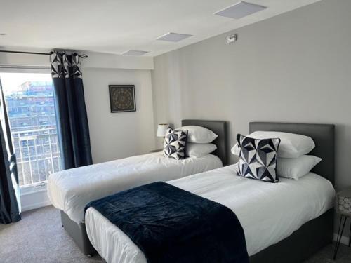 格拉斯哥Modern & Spacious 2 bed Merchant City Apart-High St的带窗户的客房内的两张床