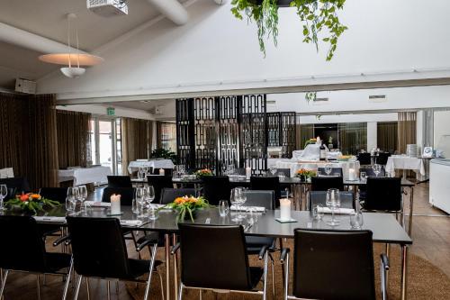 比伦德思凡恩比隆酒店的用餐室配有桌椅和鲜花