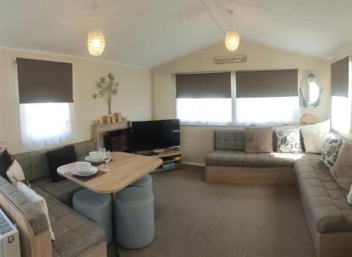 KentGriffiths, Seaview Caravan Park, Whitstable的客厅配有沙发和桌子