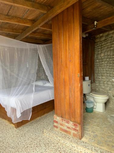 GuachacaEcoHostal Palmares Del Rio的一间卧室配有一张床和一个卫生间