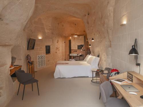 马泰拉德格里阿巴蒂宫殿酒店的石头间内一间卧室,配有一张床