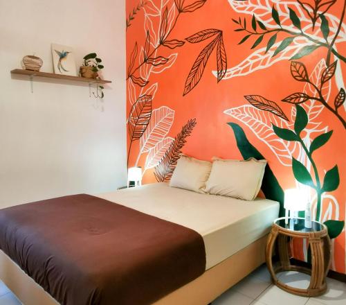 外南梦Snooze Ijen的一间卧室配有一张橙色墙壁的床
