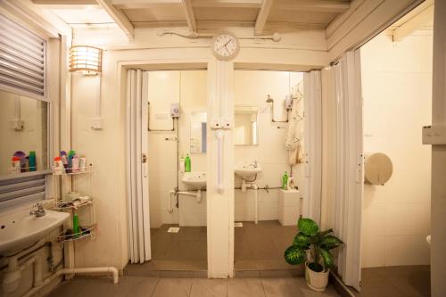 新加坡白閣便捷（新加坡）旅店的一间带水槽和墙上时钟的浴室