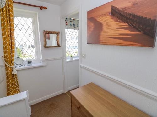 滕比Grooms Cottage的一间房间,墙上挂着一张桌子和一幅画