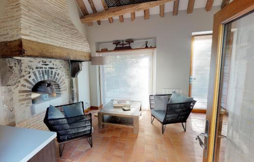 谢韦尔尼Le Petit Pavillon的客厅配有椅子和石头壁炉