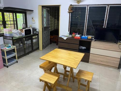 合艾Pani House Hatyai 1的厨房配有桌子和两把椅子以及电视。