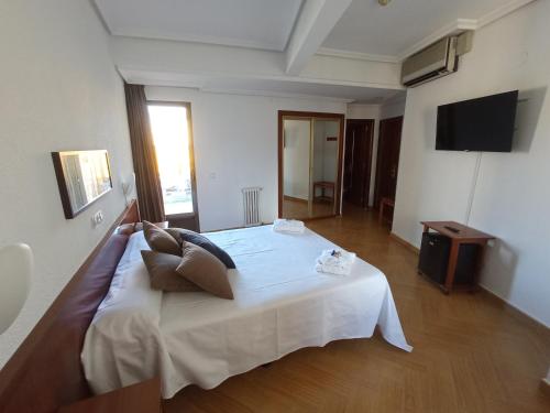 塞哥维亚Hotel ELE Acueducto的卧室配有一张白色大床