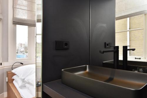海牙Boutique Hotel Havenkantoor的一间带大水槽和镜子的浴室