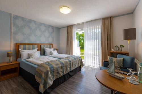 纽哈灵吉塞尔诺德斯特尔酒店的配有一张床、一张书桌和一扇窗户的酒店客房