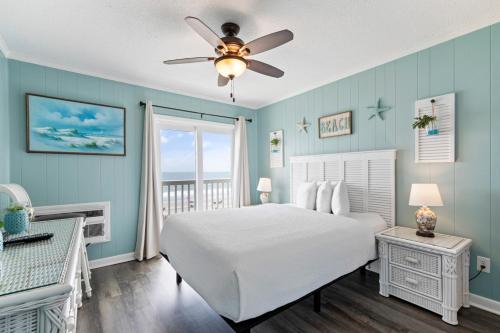 默特尔比奇Bright and Sunny Condo with Stunning Oceanfront的卧室配有白色的床和吊扇