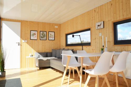 BlankaholmSchwimmendes Haus, freier Blick aufs Wasser im Schärengebiet Blankaholm inkl Boot的用餐室以及带桌椅的起居室。