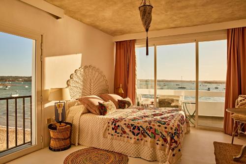 拉萨维纳Sabina Suites - Astbury Formentera的一间卧室设有一张床,享有海景