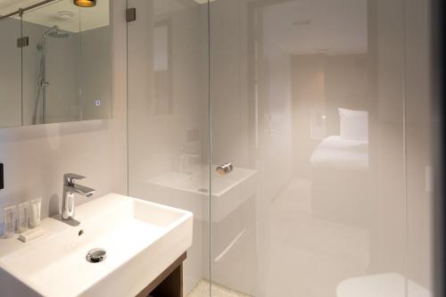 弗利辛恩Hotelboot Koningin Emma I Kloeg Collection的白色的浴室设有水槽和淋浴。