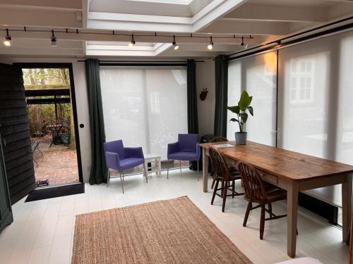 菲赫特de Merel的一间带木桌和紫色椅子的用餐室