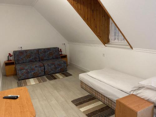 博加奇Pipacs Vendégház的客房设有床、沙发和桌子。