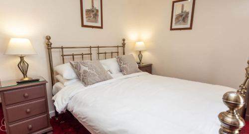 阿尼克Anglers Arms的卧室配有一张白色大床和两盏灯。