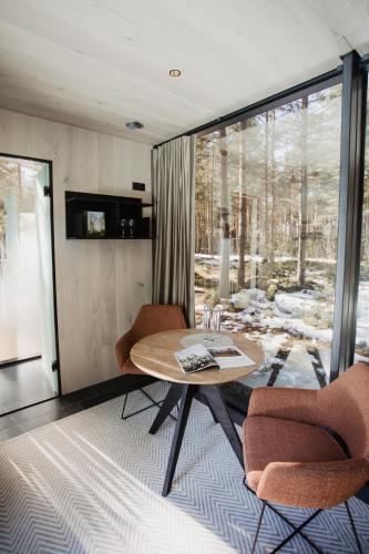 PunakiviÖÖD Hötels Laheranna SUME -with sauna的客房设有桌椅和窗户。