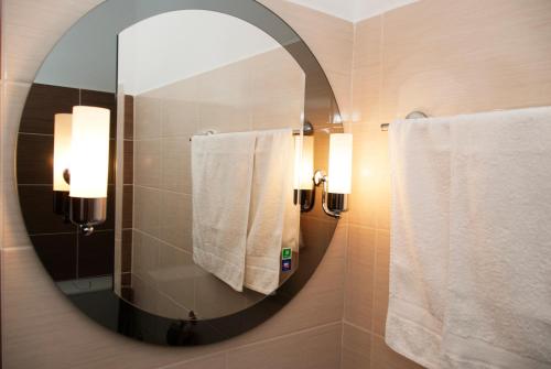 Afumaţi克里斯蒂安酒店的浴室内的镜子和白色毛巾