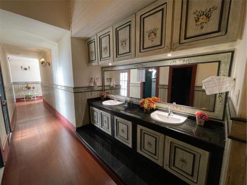兰巴里Pousada do Duque的大型浴室设有两个盥洗盆和大镜子