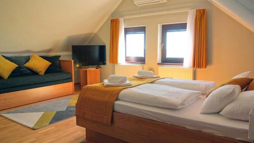 蒂豪尼Ferenc Vendégház的一间卧室配有一张大床和一张沙发