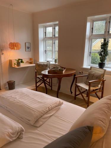 StenstrupFeriehus i skøn natur的卧室配有一张床和一张桌子及椅子