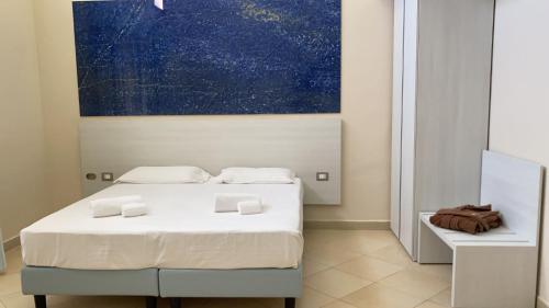 蒂勒尼亚Toscana Sport Resort的一间卧室设有两张床,墙上挂着一幅画