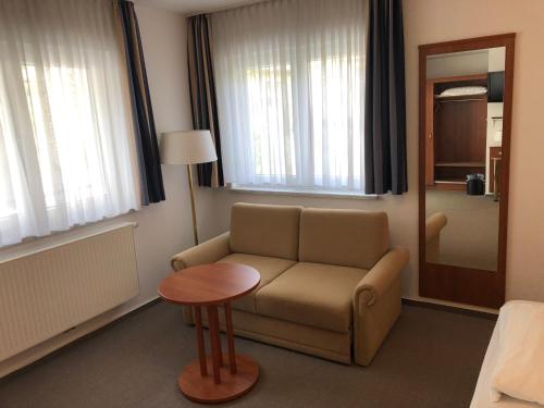 布劳巴赫Hotel Garni Rabennest的客厅配有沙发和桌子
