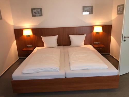 布劳巴赫Hotel Garni Rabennest的一间卧室配有一张带两个白色枕头的床