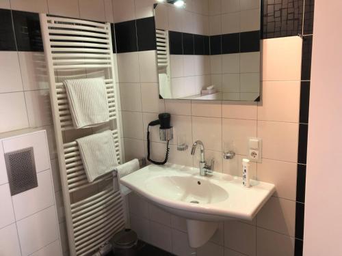 布劳巴赫Hotel Garni Rabennest的一间带水槽和镜子的浴室
