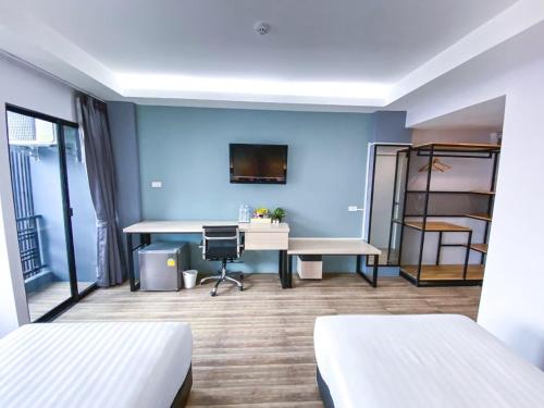 呵叻MtriO Hotel Korat的客房设有两张床和一张书桌。