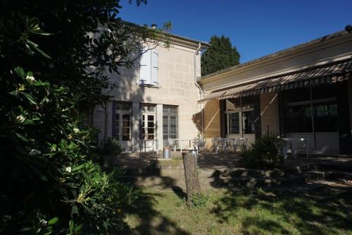 阿尔勒Auberge de Jeunesse HI Arles的庭院内带庭院和椅子的房子