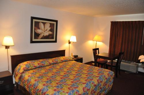 博蒙特Heritage Inn的配有一张床和一张书桌的酒店客房