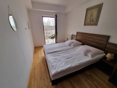 奥尔什蒂内克Apartament Perła A20 nad jeziorem Pluszne的卧室配有一张带白色床单的大床和窗户。