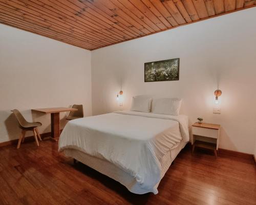 坎波斯杜若尔当Casa Wald的卧室设有白色的床和木制天花板。