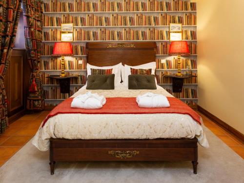 波尔图迷人的安泰楼旅馆的一间卧室配有一张带书架的大床