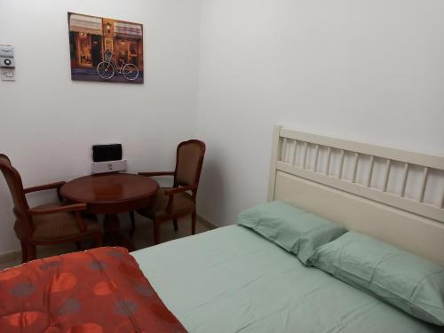 沙迦Furnished Apartment的卧室配有一张床和一张桌子及椅子