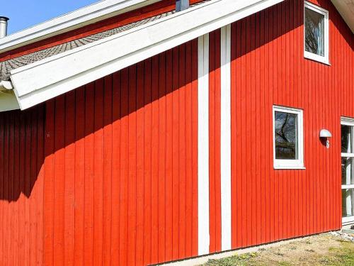 诺德堡12 person holiday home in Nordborg的红谷仓的一侧有白色条纹