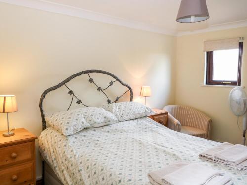 HenfieldThe Granary的一间卧室配有一张床、两盏灯和一个窗户。