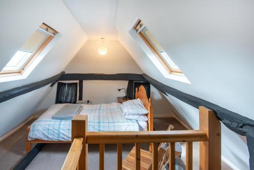 马基特雷森Woodbine Cottage的阁楼卧室配有一张床和天窗